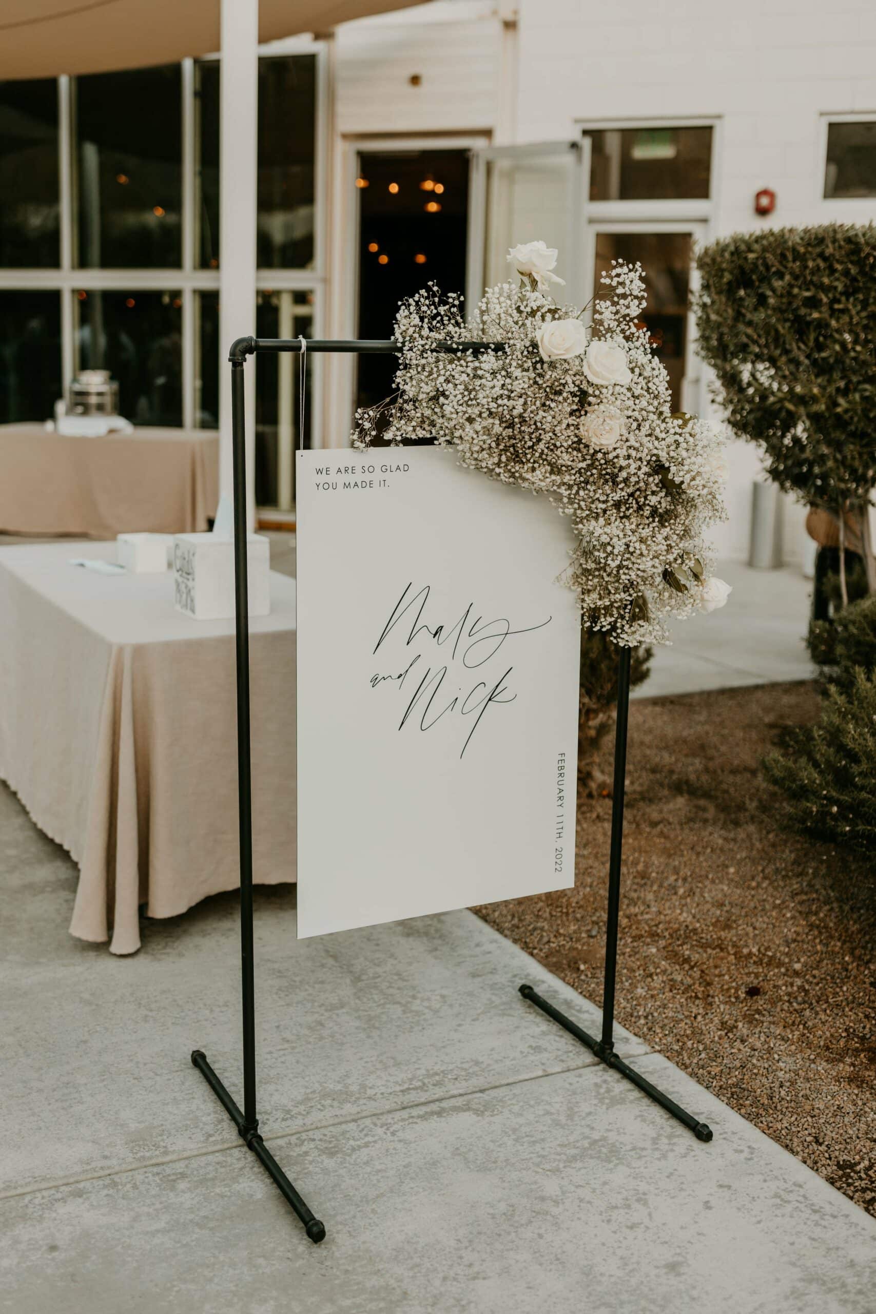 black white welcome sign black stand babys breath monochromatic
